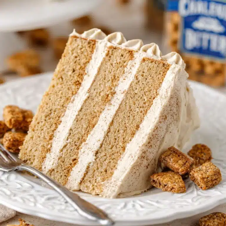 Close-up of a three-layer churro cake slice with cinnamon sugar frosting and cereal crumbs on a white plate