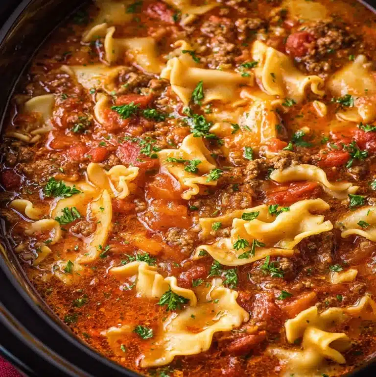 Close-up of slow cooker lasagna soup with ground beef, curly lasagna noodles, and tomato basil broth