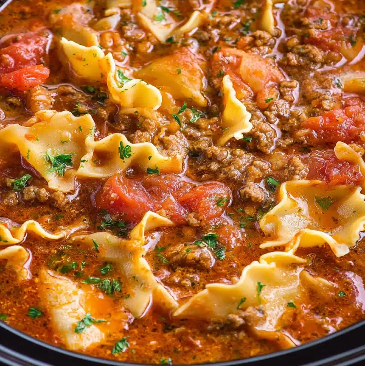 Slow cooker lasagna soup in a bowl with ricotta and basil