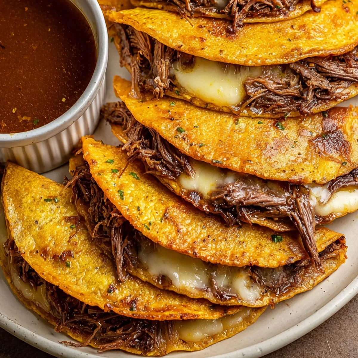 Birria Tacos – Slow Cooker Cheesy Beef Recipe 6 Birria tacos served with lime wedges, cilantro, and pico de gallo on a rustic plate