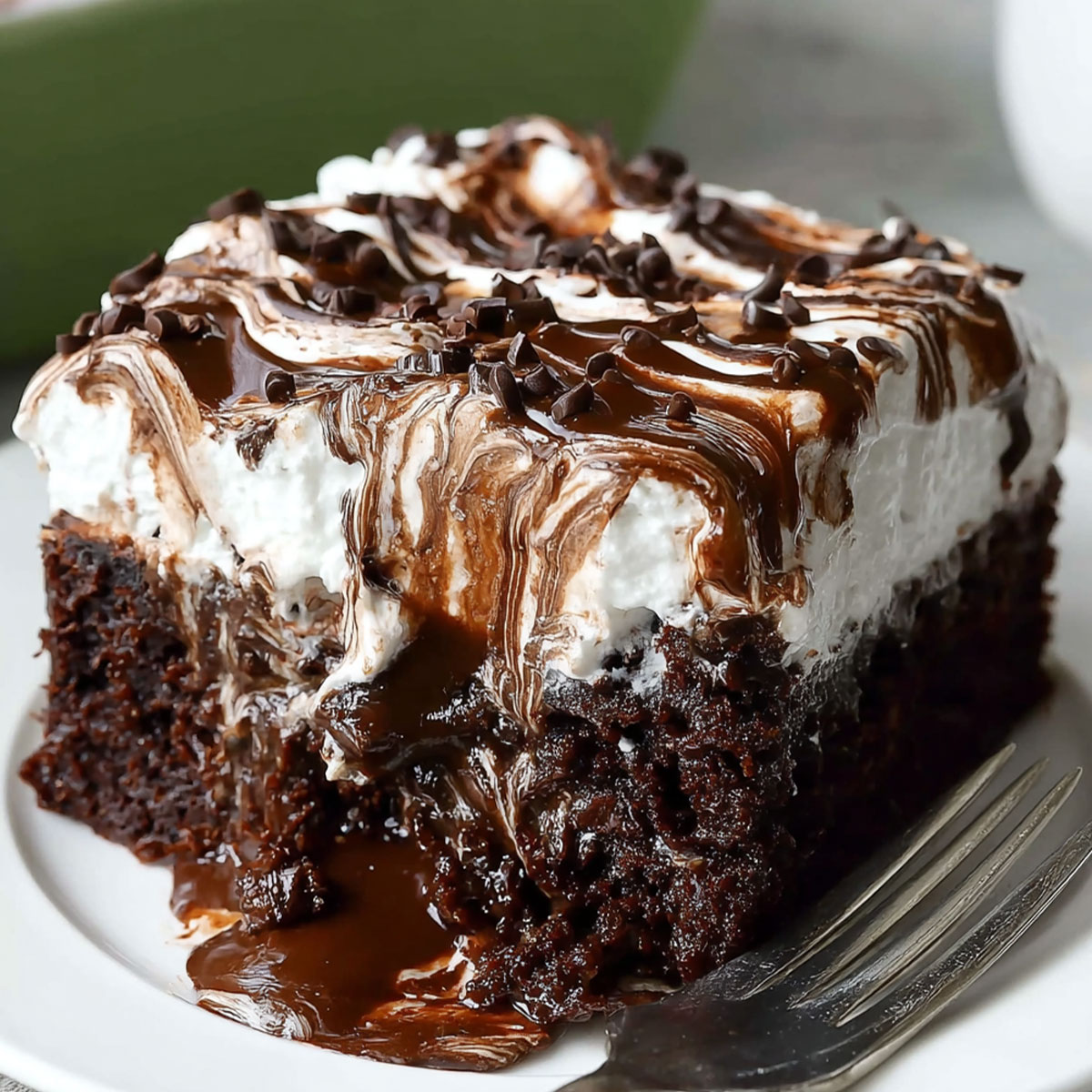 Chocolate Poke Cake with Marshmallow topping dripping with rich chocolate ganache and fluffy whipped cream