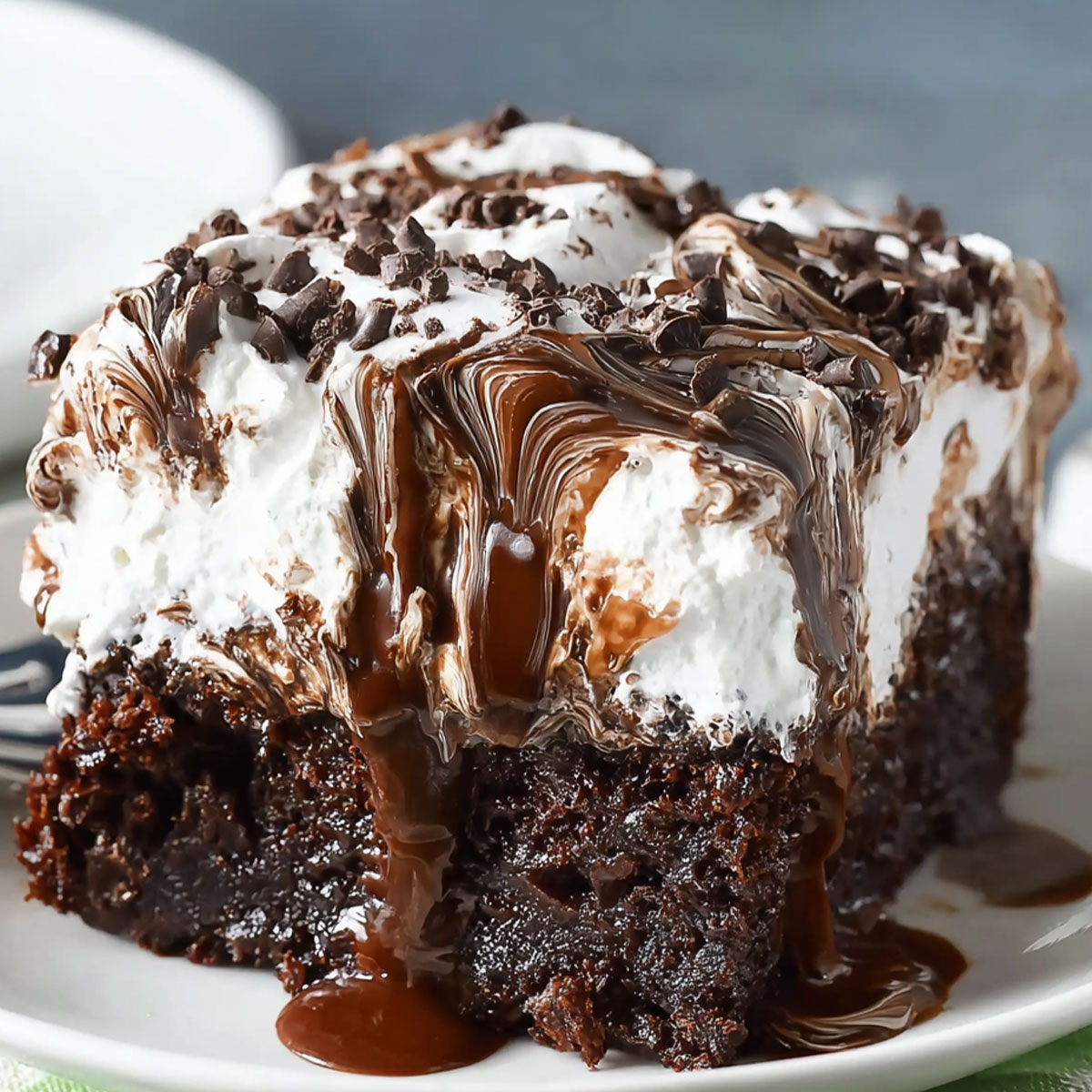 Pouring warm chocolate ganache over Marshmallow-topped Chocolate Poke Cake