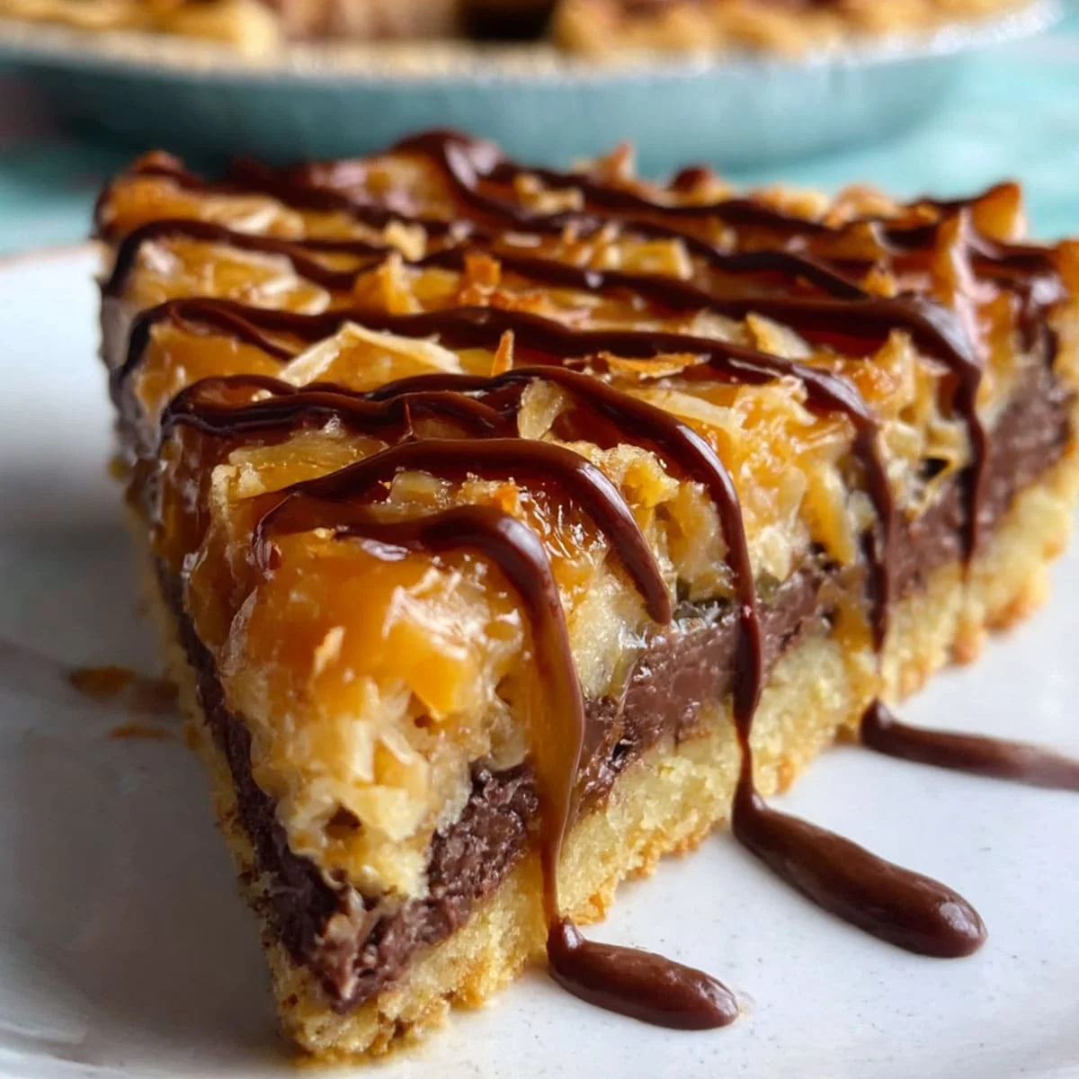Rich Samoa Pie slice showing caramel drizzle, toasted coconut, and layers of chocolate on a golden crust