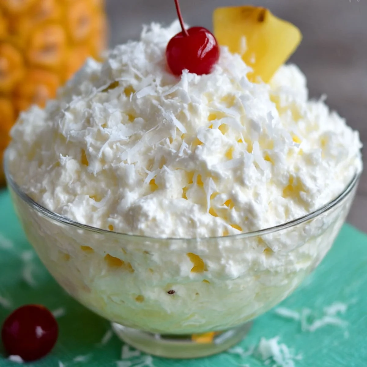 Glass bowl of classic Pina Colada Fluff with cherry on top