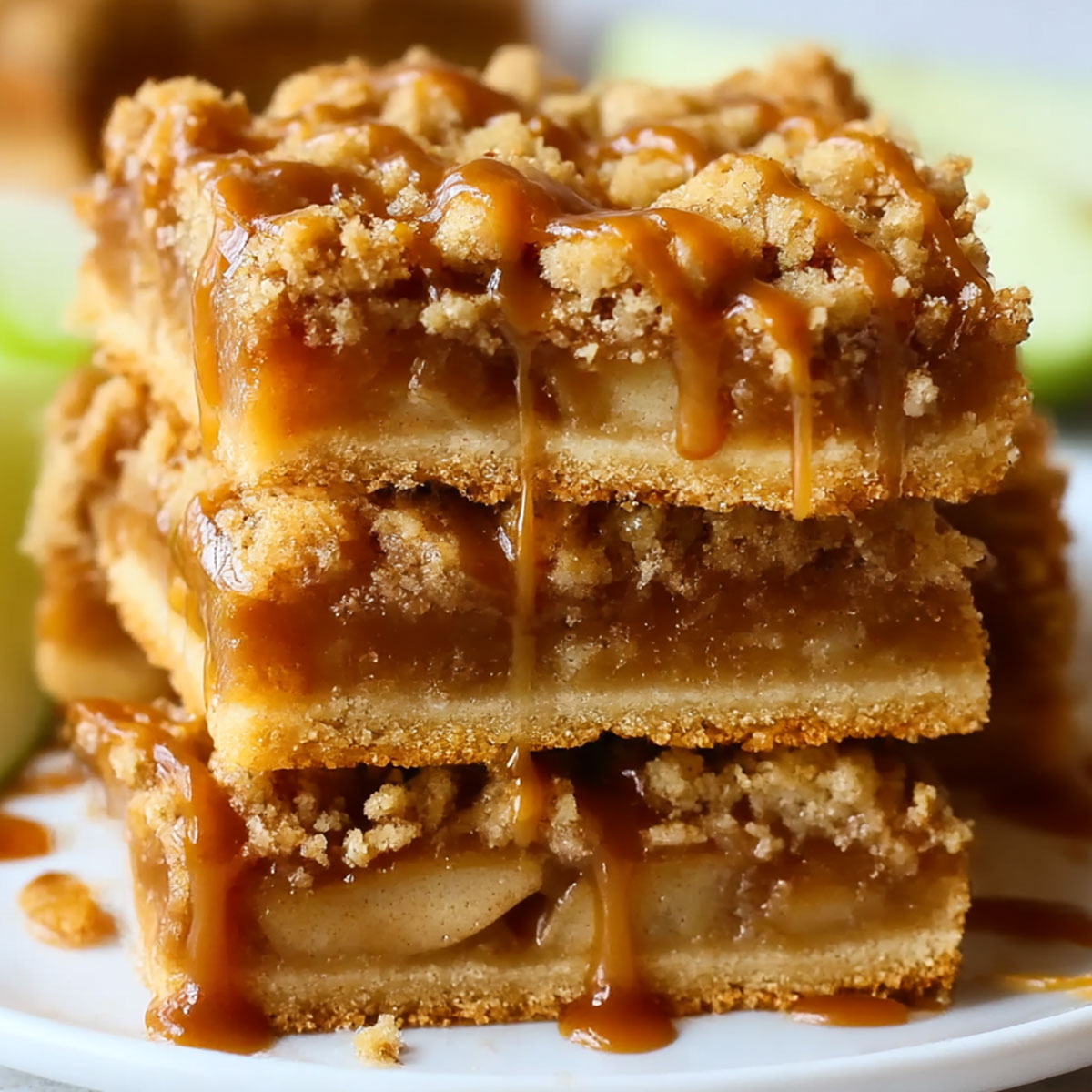 Salted Caramel Apple Pie Bars stacked high with crisp streusel topping and salted caramel drizzle