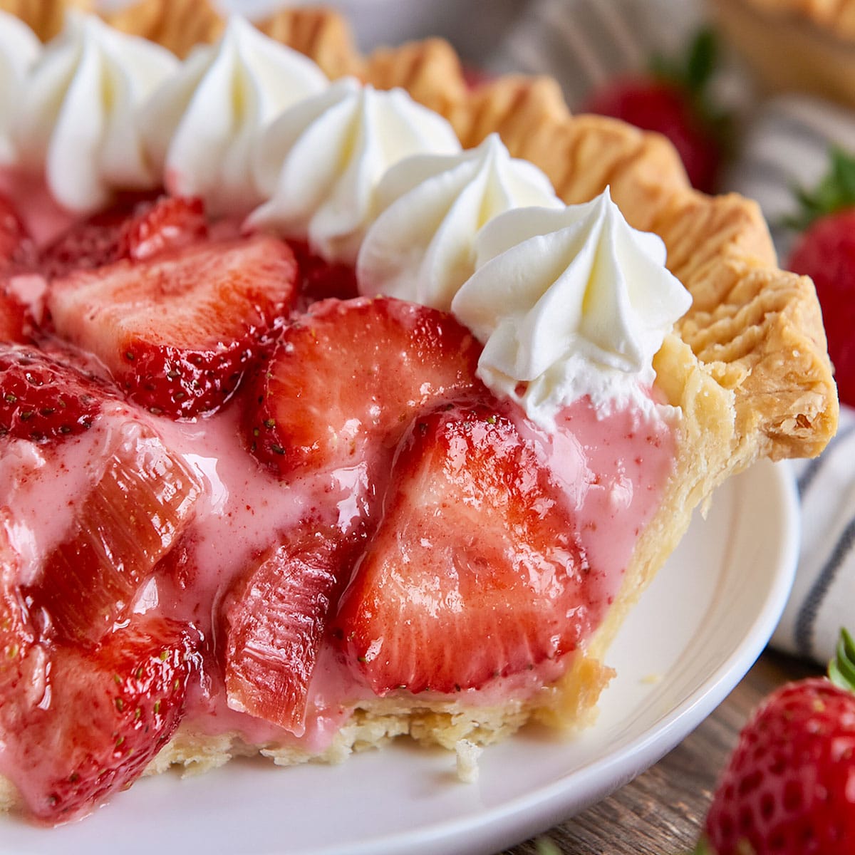 Strawberry Rhubarb Pie with glossy strawberry slices, pink rhubarb chunks, creamy filling, and golden pie crust